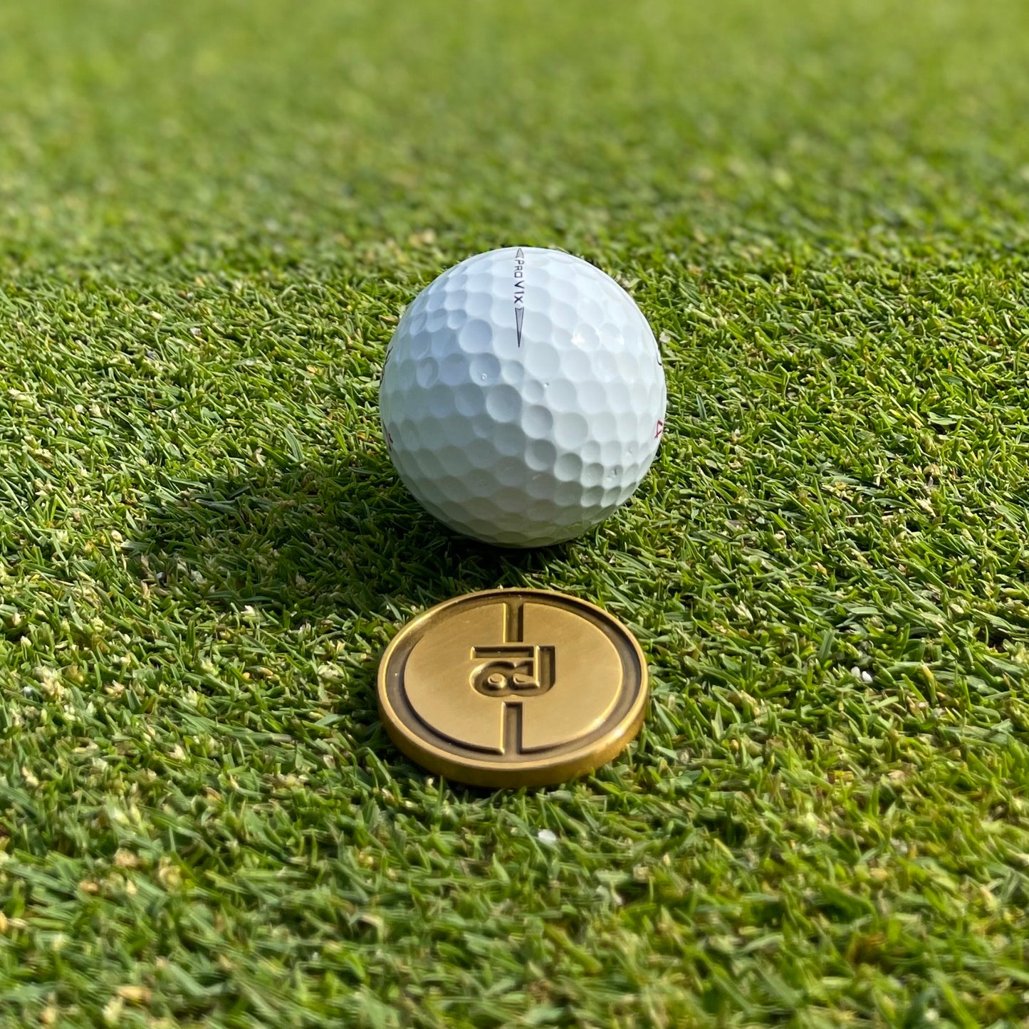 Golf Ballmarker und Divottool Gold in Geschenkbox von 18Undergolfclub auf einem Golfgrün. Putting Green Performance Set.