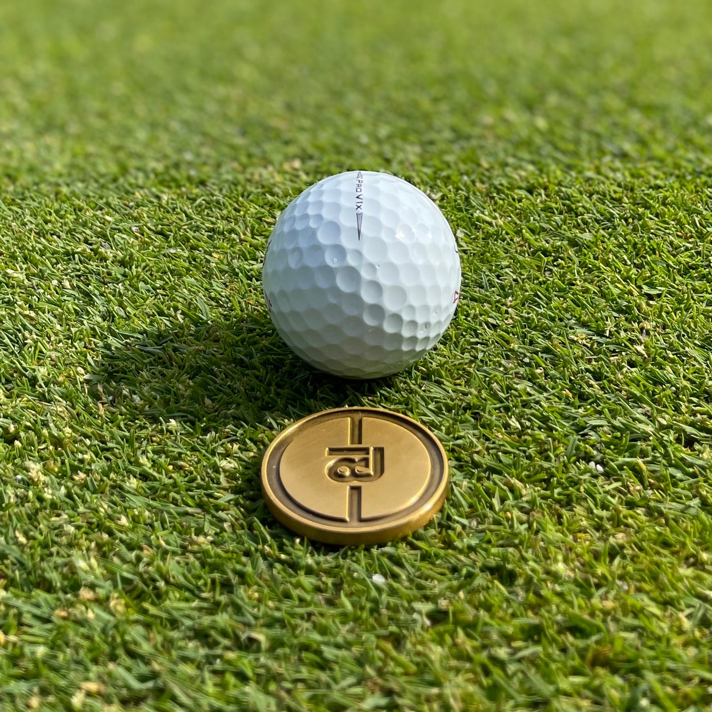Golf Ballmarker  und Divottool Gold in Geschenkbox von 18Undergolfclub auf einem Golfgrün. Putting Green Performance Set.